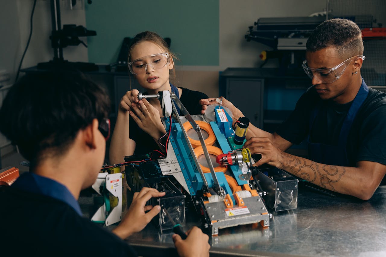 Engineers collaborating in a workshop, assembling a robotic device with teamwork and precision.